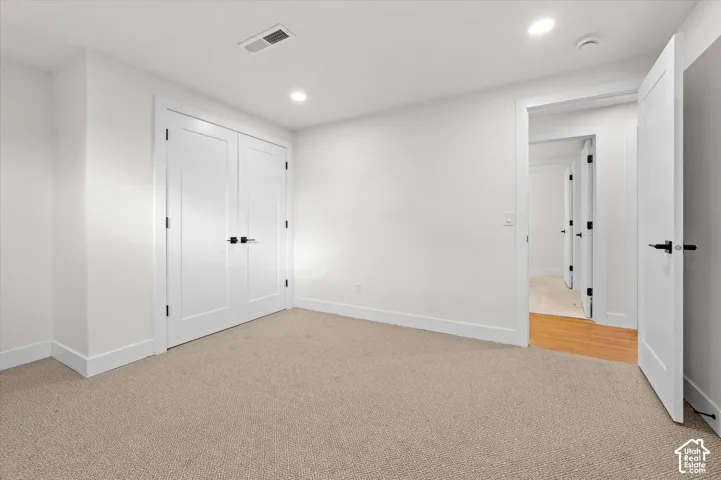 Bright interior room featuring neutral carpeting and white walls