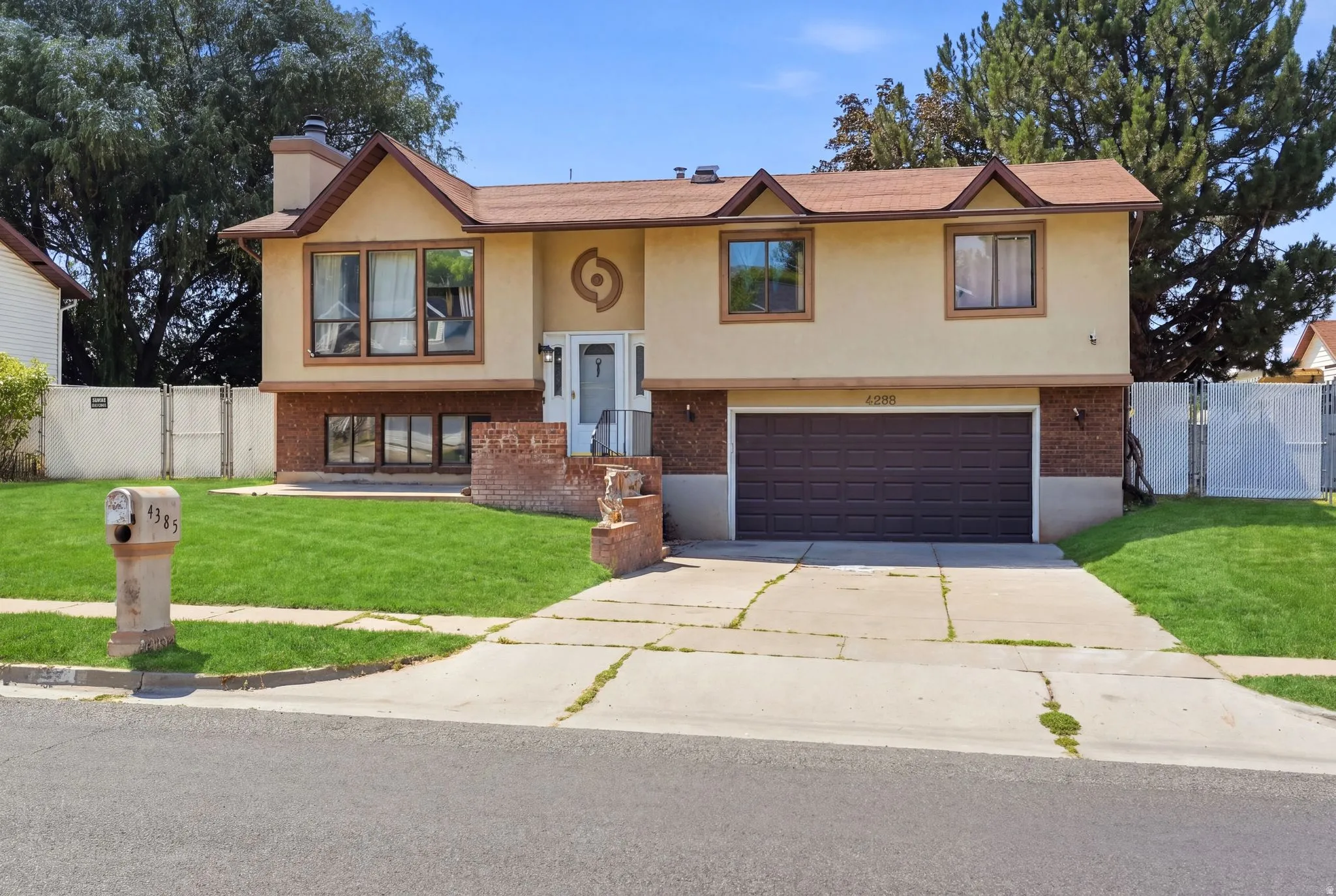 Stucco and brick facade with a prominent bay window and an integrated two-car garage