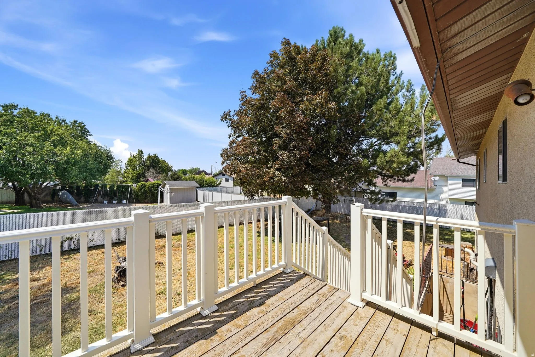 Wood-finish deck with white railings and an outdoor light fixture