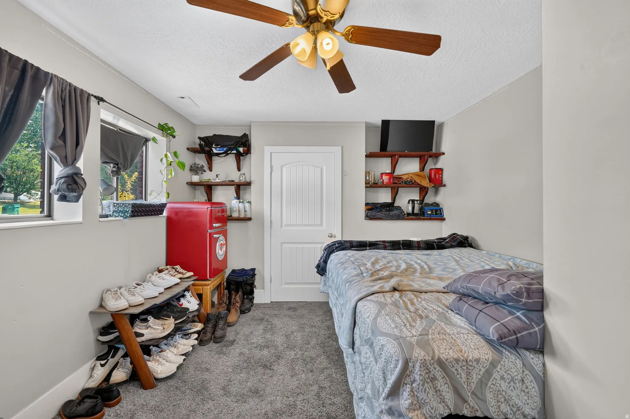 Hardwood-look ceiling fan, wall-mounted shelving units, and two windows with trim