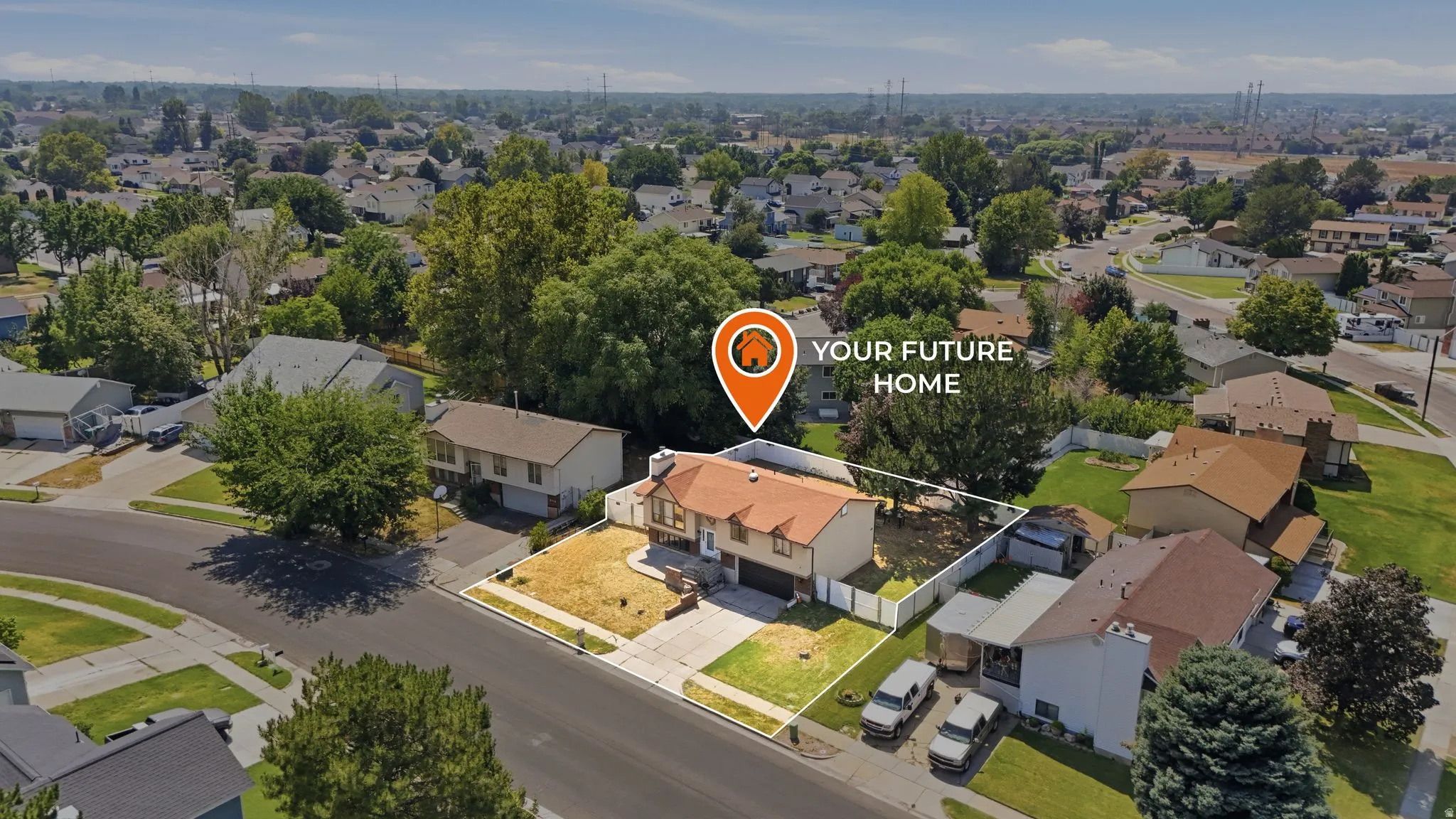 Multi-level residential property with an attached garage, a paved driveway, and a fenced backyard