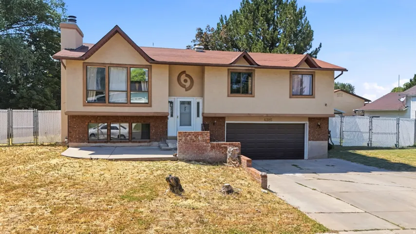 Split-level residence featuring a two-car garage, brick accents, and a front entry with sidelight