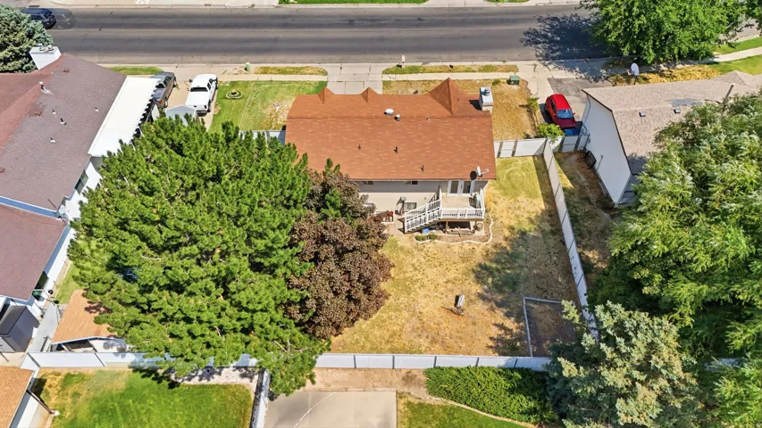 Expansive residential lot featuring a freshly re-roofed home with new copper/metal roofing, mature landscaping with established trees throughout the property, and a generous yard with ample space for outdoor activities