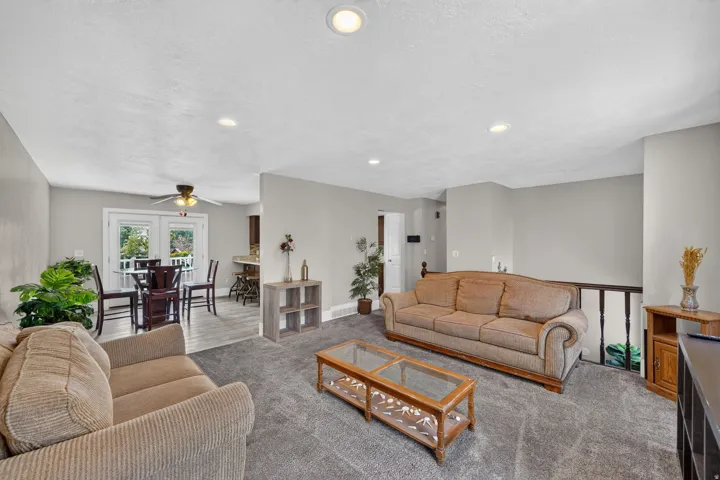 Spacious open-concept living area featuring neutral wall finishes, recessed ceiling lighting, and a wood-finish coffee table