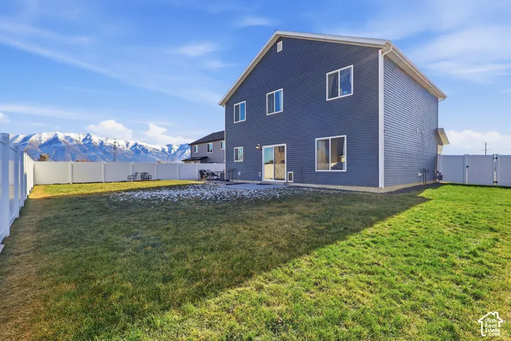 Expansive backyard featuring a manicured lawn, full perimeter fencing, and a concrete patio
