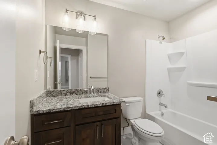 Bathroom featuring a dark wood-finish vanity with a light speckled countertop, an undermount sink, and a brushed nickel faucet