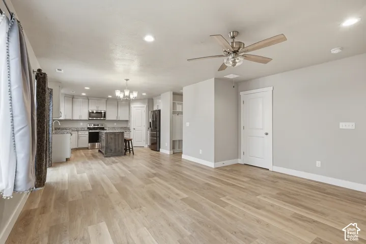 Open-concept living space featuring wood-finish flooring, recessed lighting, and a contemporary ceiling fan