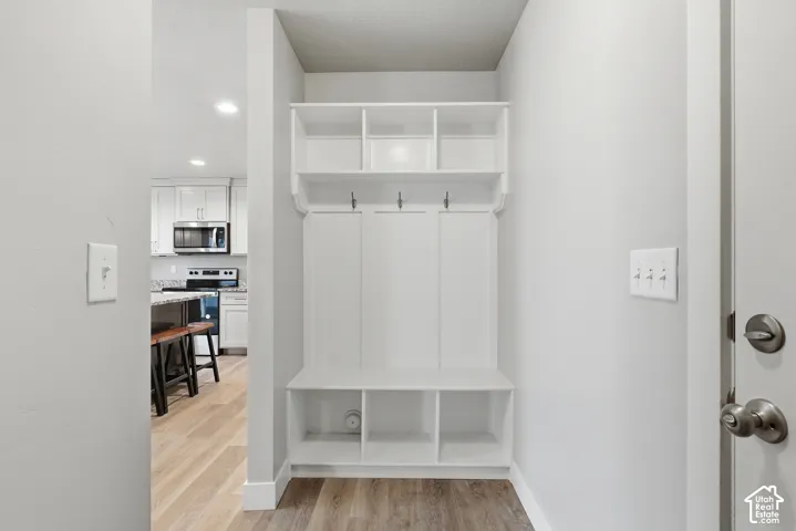 Built-in mudroom storage featuring coat hooks, upper shelving, and lower cubbies