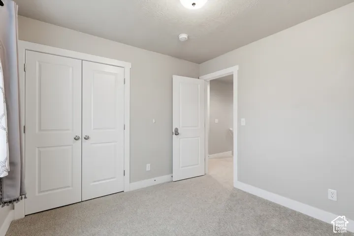 Room featuring light neutral wall paint, white trim, and light gray carpet flooring