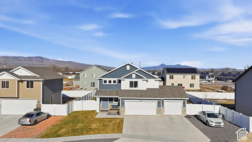 Modern two-story residence featuring a two-car garage, partial stone facade, and a covered entryway