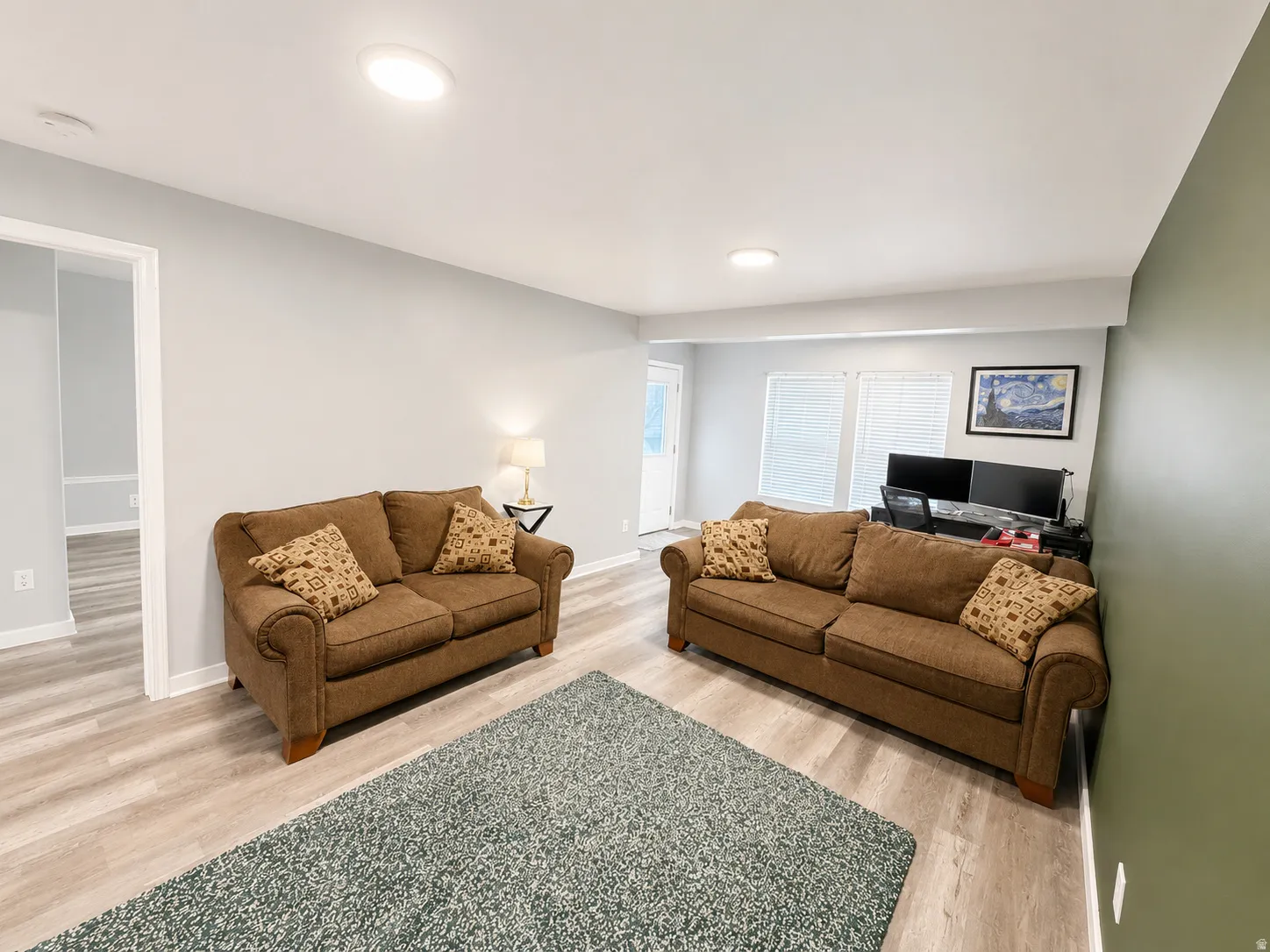 Spacious living area featuring wood-finish flooring, recessed lighting, and a neutral color palette