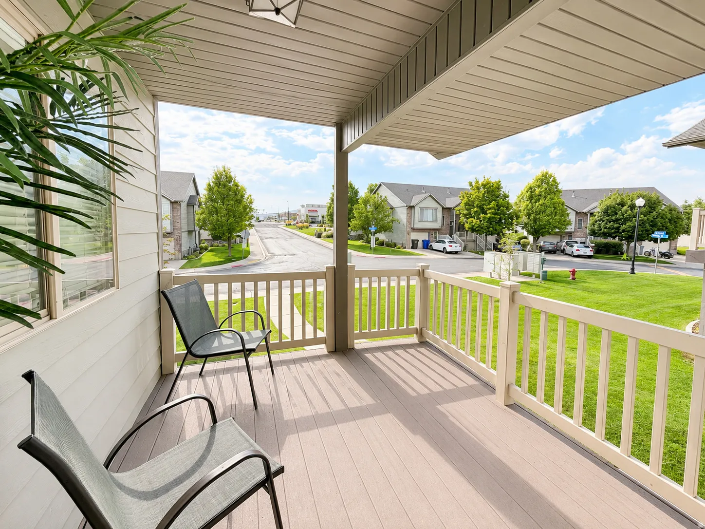 Covered porch featuring durable decking, light-toned siding, and a decorative outdoor light fixture