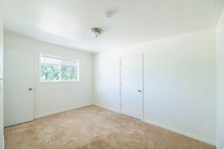 Neutral white wall tones with a window featuring horizontal blinds