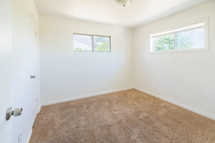 Neutral-toned carpeting extends throughout this room, complemented by white walls and trim