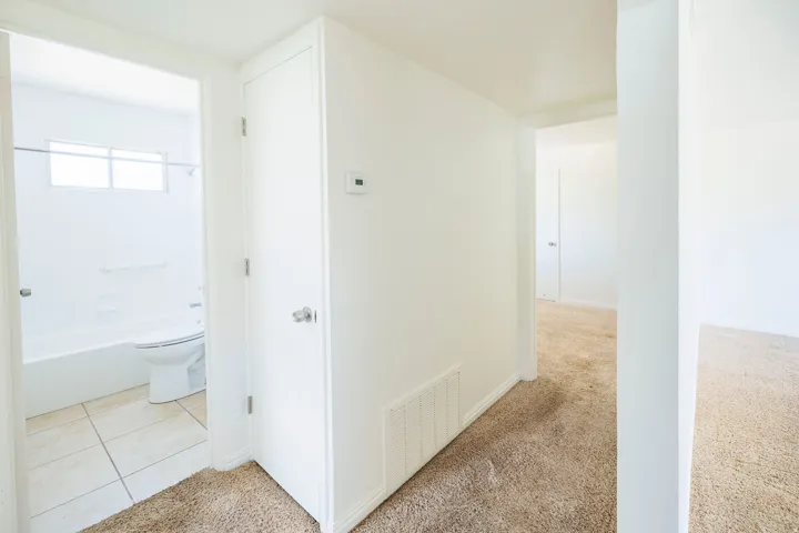 Bathroom featuring a tub/shower combination, white toilet, and tile flooring