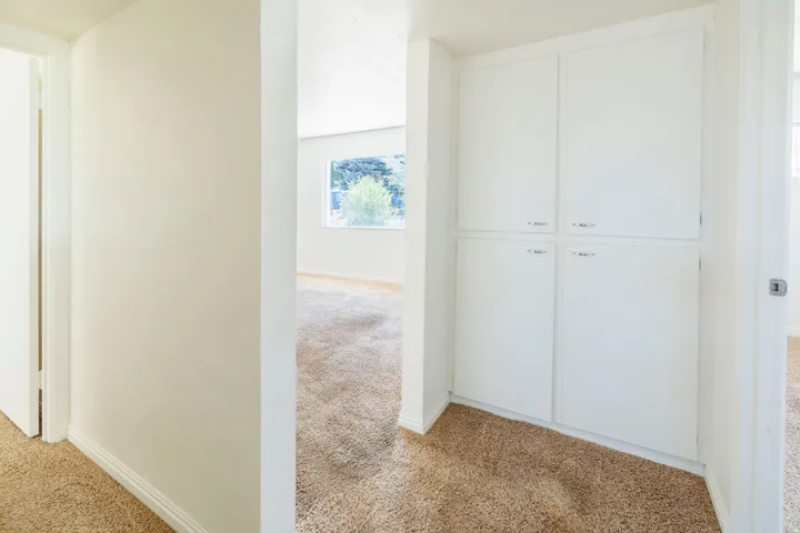 Built-in cabinetry with four white panel doors and silver-tone hardware