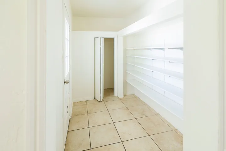 Spacious utility area featuring neutral square tile flooring