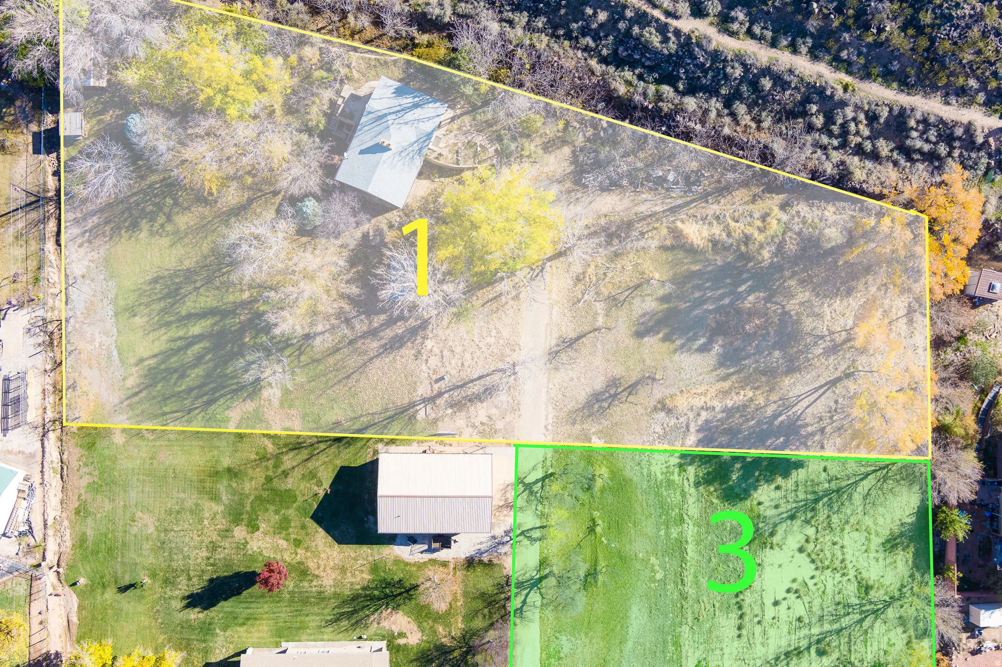 Aerial perspective showcasing expansive land parcels, outlined in yellow and green, featuring diverse ground cover and mature trees