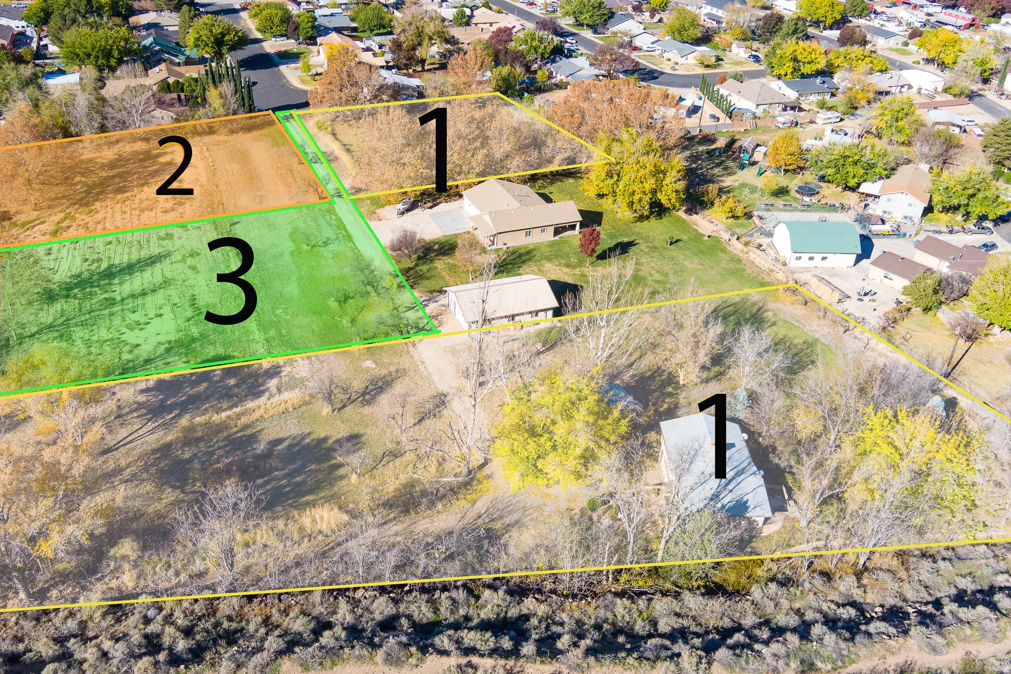 Aerial perspective of multiple land parcels, including lot 3 featuring a green, cleared area
