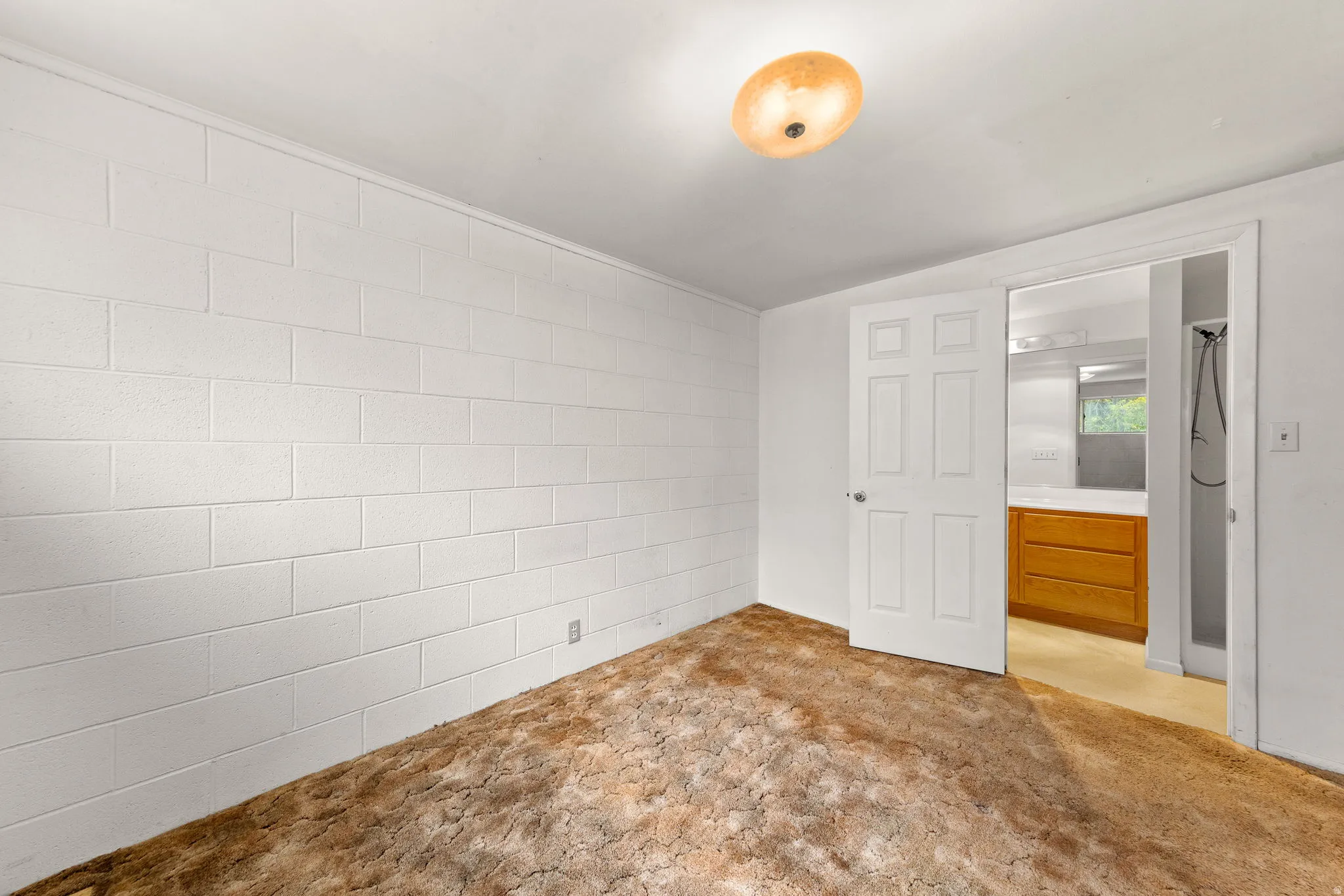Interior room featuring white painted block walls and a ceiling-mounted light fixture