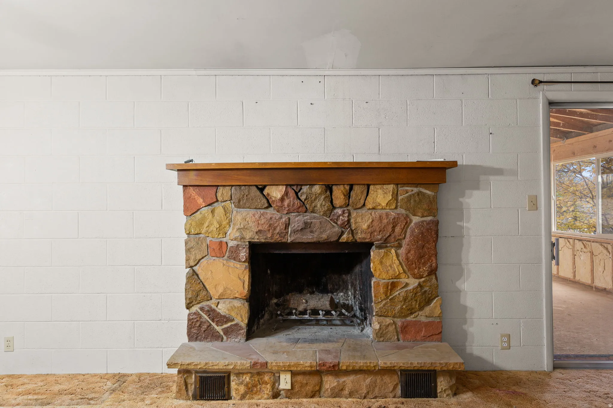 Stone-clad fireplace with a wood mantel and hearth