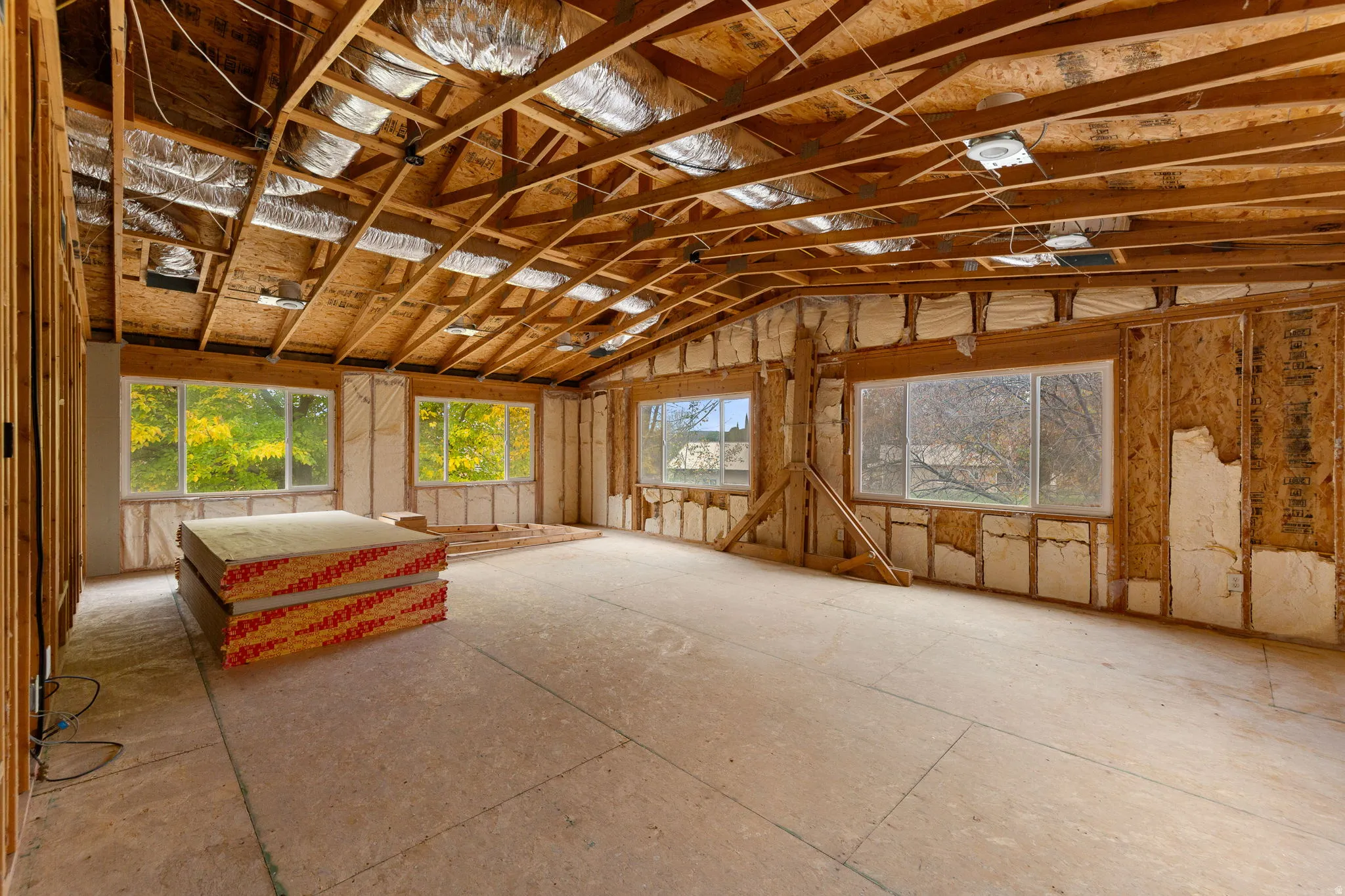 Spacious unfinished interior framing with exposed wood beams and subflooring