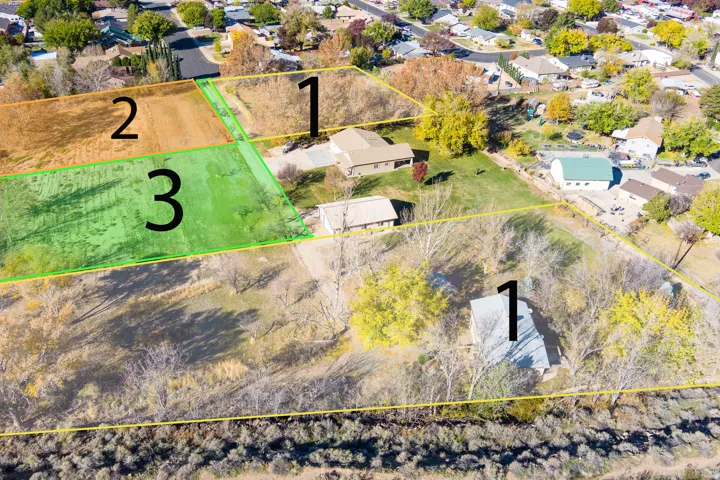 Aerial perspective of multiple land parcels, including lot 3 featuring a green, cleared area