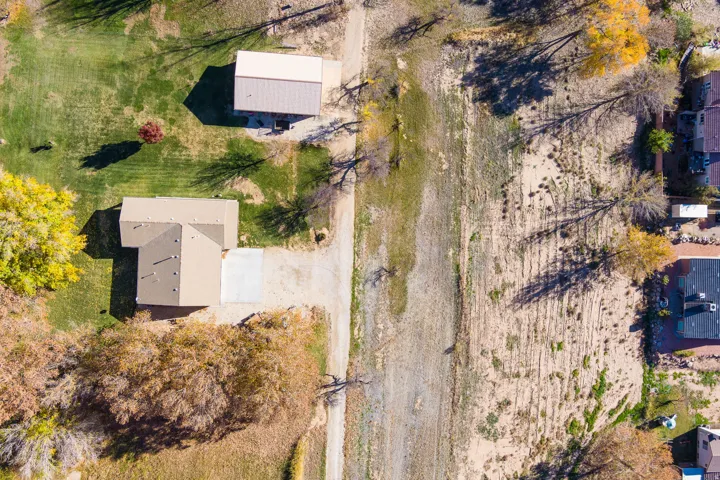 Aerial perspective showcasing a property with a primary residence, a detached auxiliary building, and a driveway