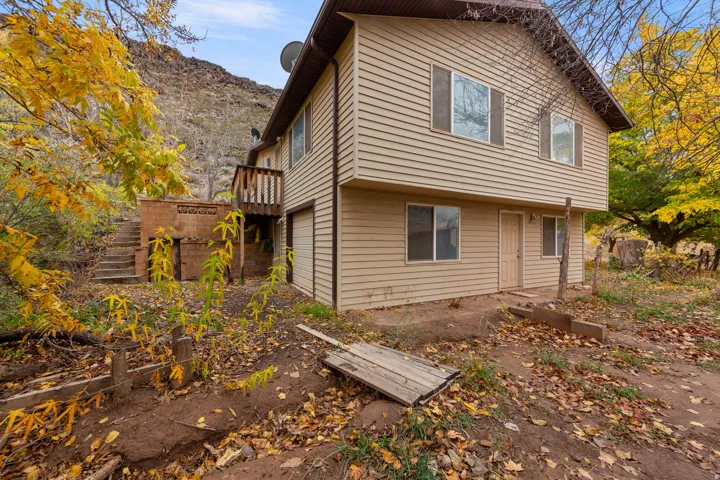 Two-story residence featuring horizontal siding, multiple windows, and a second-level balcony