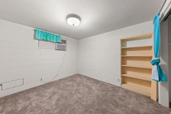 Carpeted room featuring white block walls
