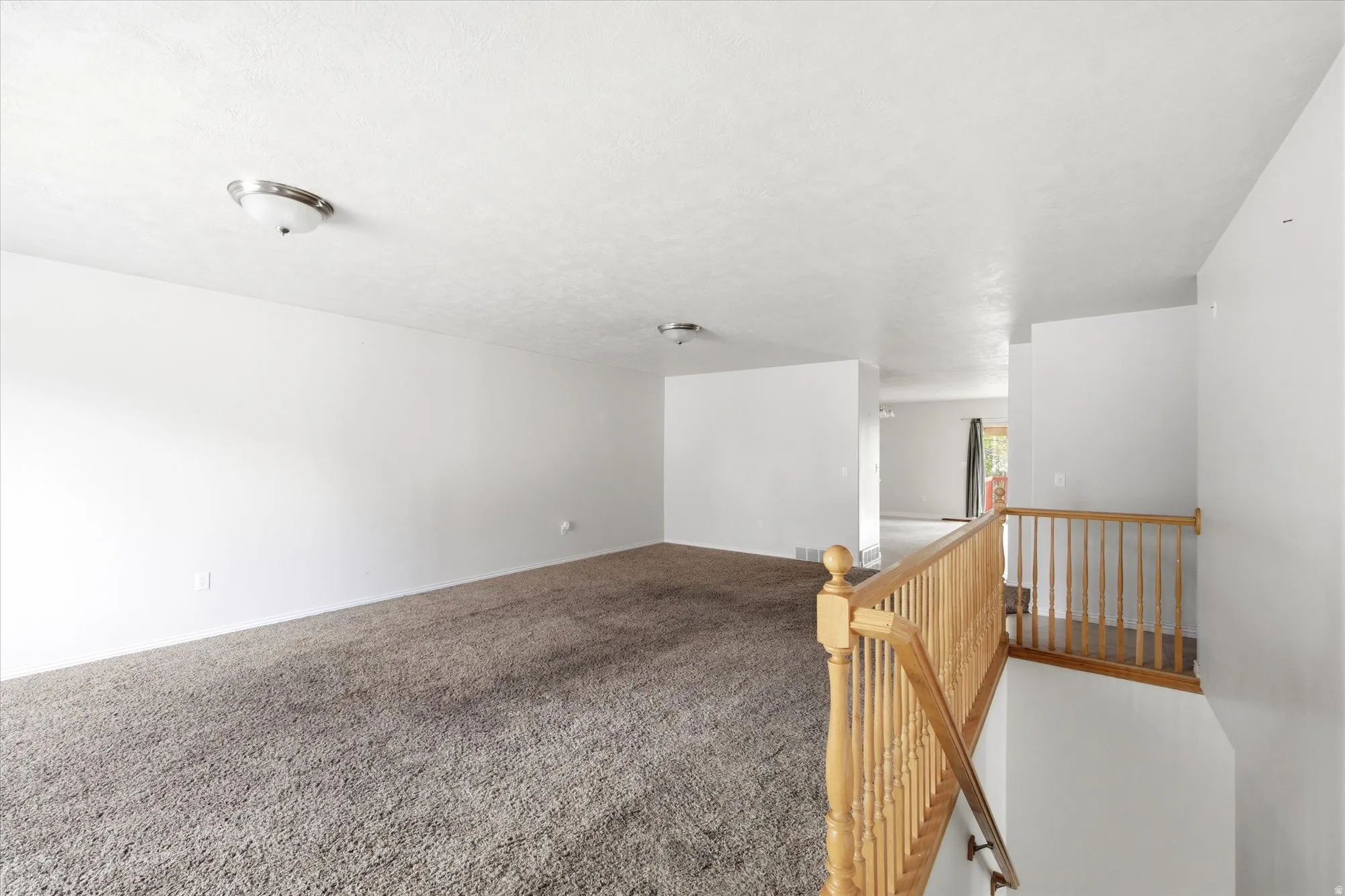 Spacious interior featuring neutral carpeting and white walls
