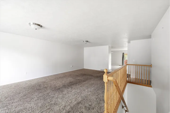 Spacious interior featuring neutral carpeting and white walls