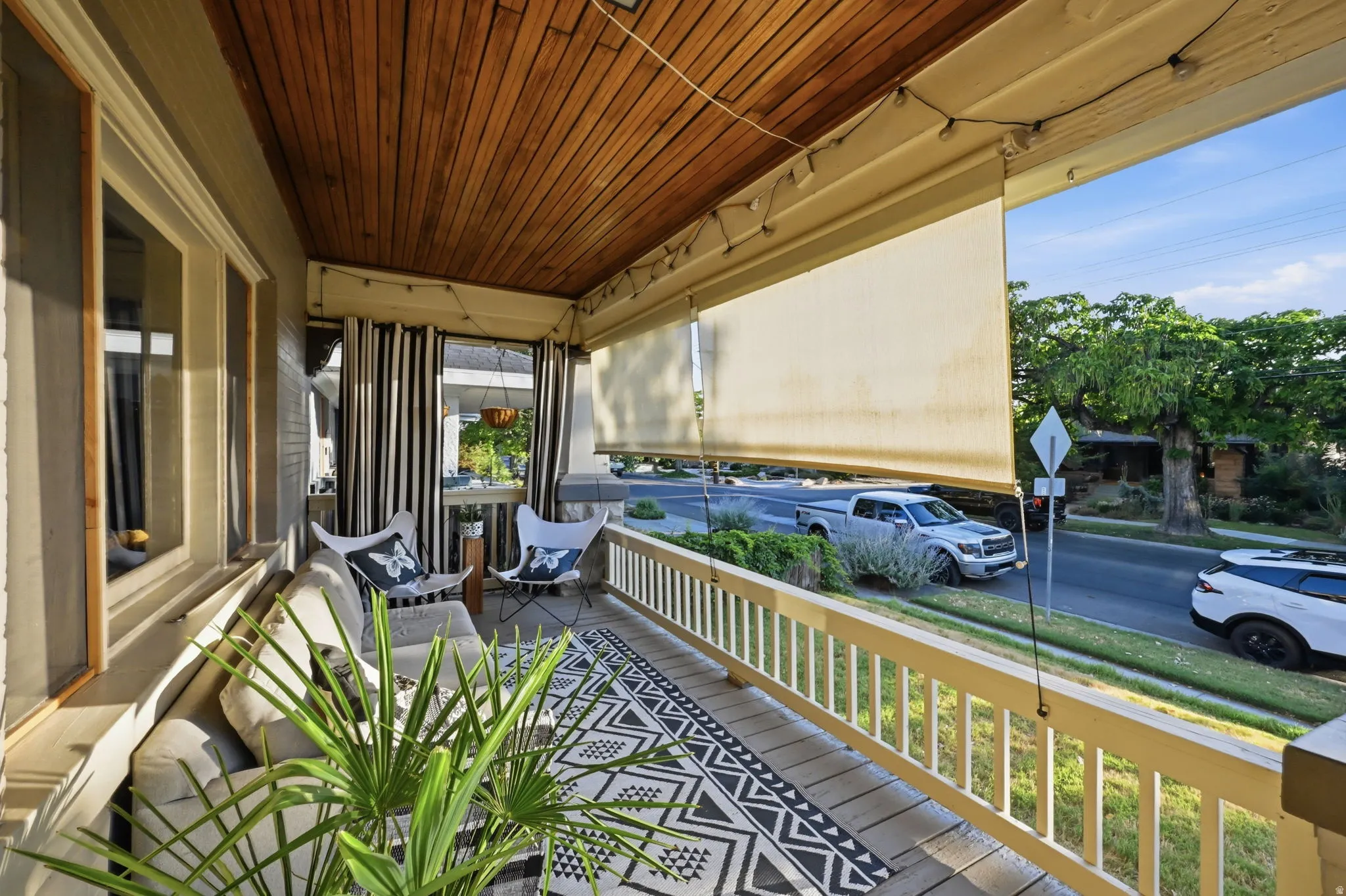 Covered porch featuring a wood-finish ceiling, light-toned wall siding, privacy screens, and wood railings