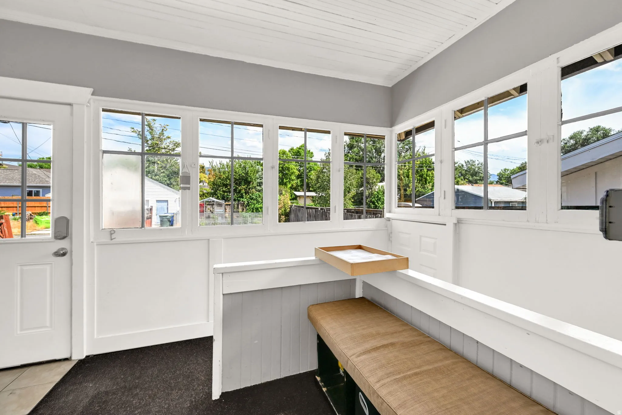 Enclosed porch featuring multiple large windows, a paneled ceiling