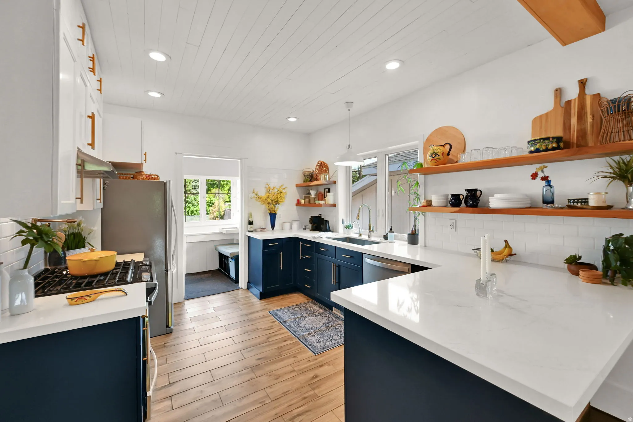 Contemporary kitchen featuring wood-finish flooring tiles and a shiplap ceiling