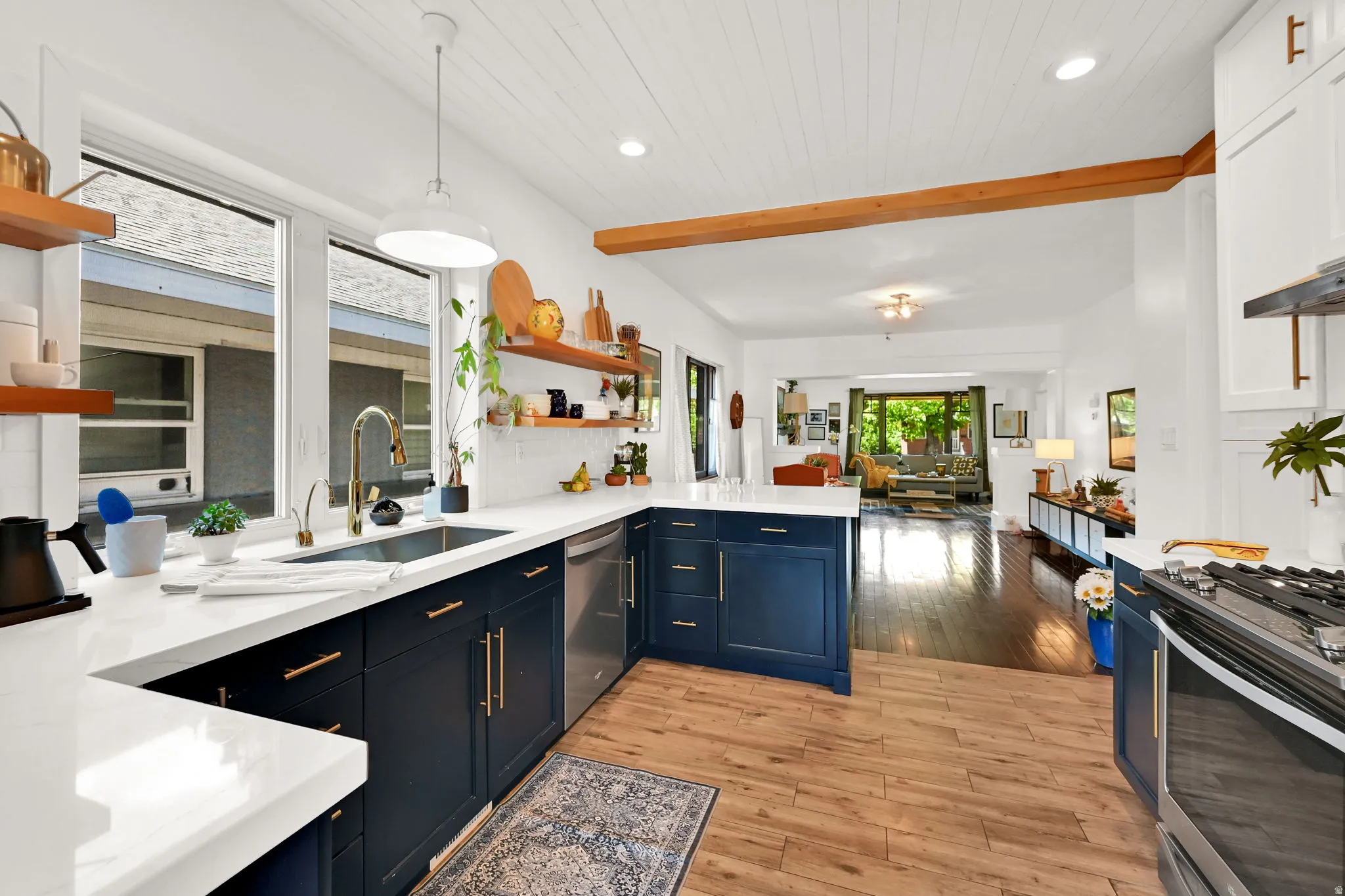 Modern kitchen featuring white countertops, navy blue cabinetry, stainless steel appliances