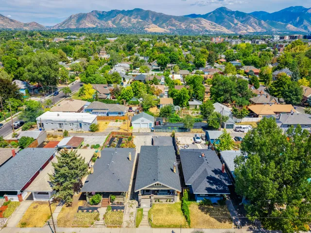 Residential properties featuring varied architectural styles and established landscaping, set against a backdrop of distant mountains