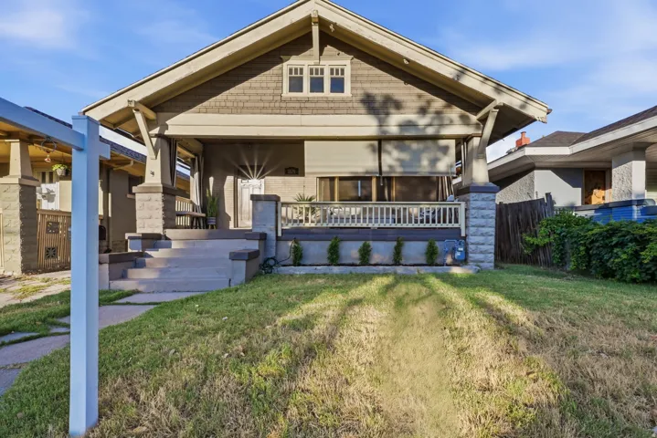 Craftsman-style facade with a prominent front porch and stone-clad columns