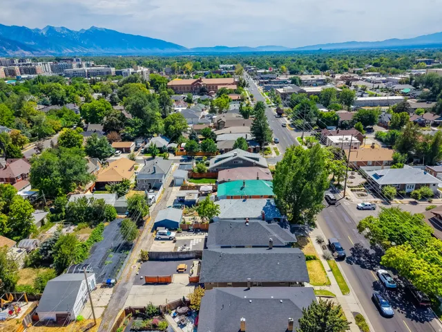Aerial perspective showcasing a residential area with mature trees and a distant mountain range