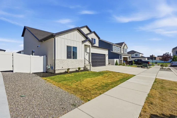 Contemporary two-story exterior featuring white vertical siding and stone accents