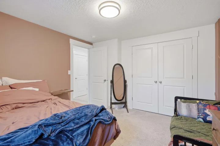 Bedroom featuring neutral carpet flooring, recessed lighting, white trim, and white bi-fold closet doors