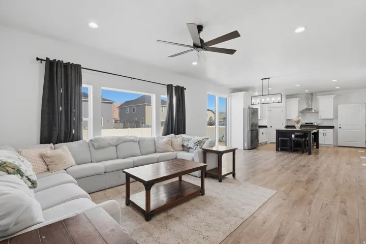Open-concept living area featuring wood-finish flooring, recessed lighting, and a ceiling fan