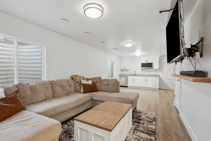Open-concept living space featuring wood-finish flooring and multiple flush-mount ceiling lights