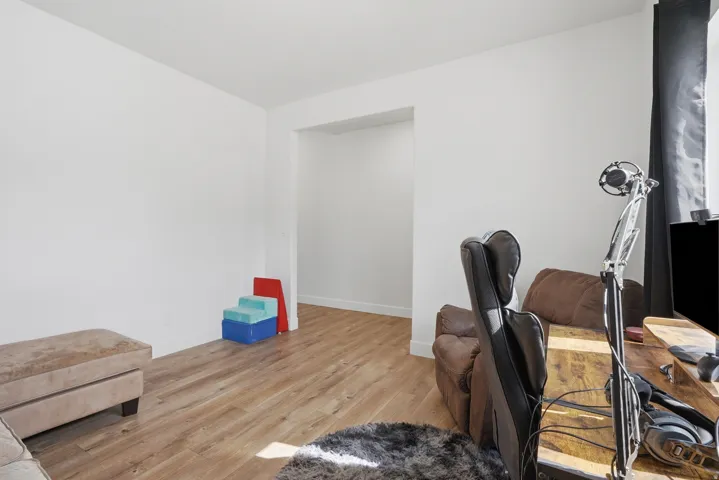 Room featuring wood-finish flooring and an open doorway