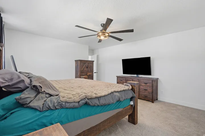 Spacious room featuring light-colored walls and soft carpet flooring