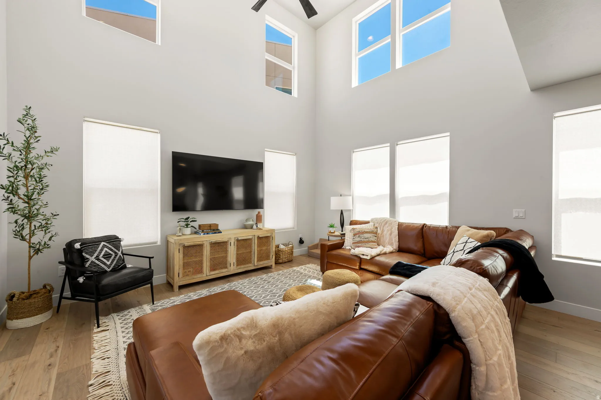 Living area featuring high ceilings, upper transom windows, and wood-finish flooring