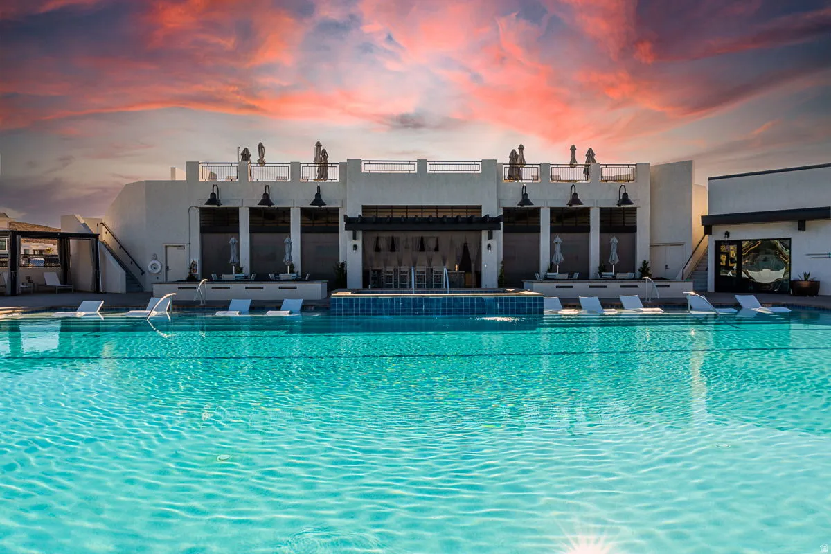 Resort-style pool with integrated loungers and water features, set against a multi-level building