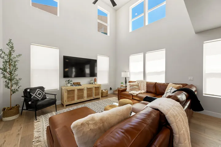 Living area featuring high ceilings, upper transom windows, and wood-finish flooring