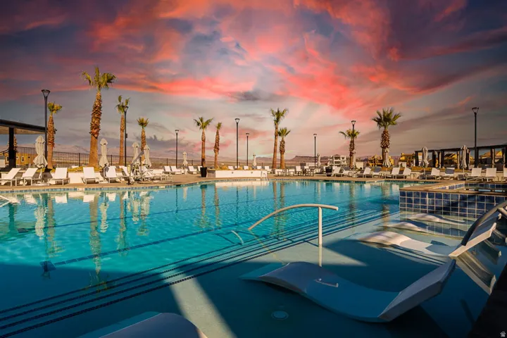 Resort-style swimming pool featuring integrated lounge seating and a tiled spa area