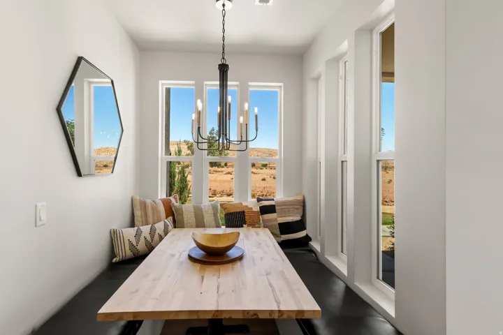Integrated dining nook with a wood-finish table, built-in bench seating, and an overhead chandelier